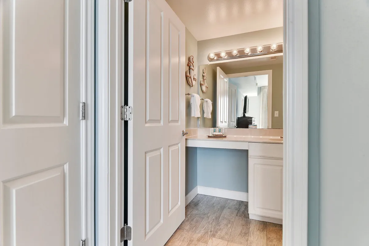 A modern bathroom with a well-lit vanity mirror, sleek sink, towel rack, and bright fixtures. The clean, refreshing space is designed for self-care and comfort, echoing the ensuite and hall bathrooms described in the section.